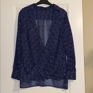 Crossover blue blouse with white dots. Sheer.Longer back to cover bottom.